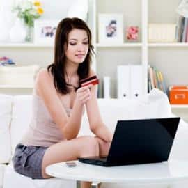 Woman with credit card and laptop at home