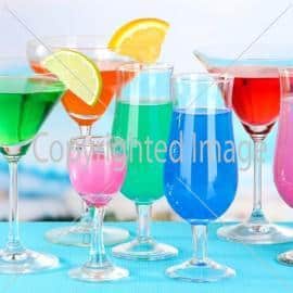 Glasses of cocktails on table near pool