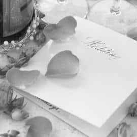 Wedding Invitation Next To Champagne Bottle Surrounded By Flower